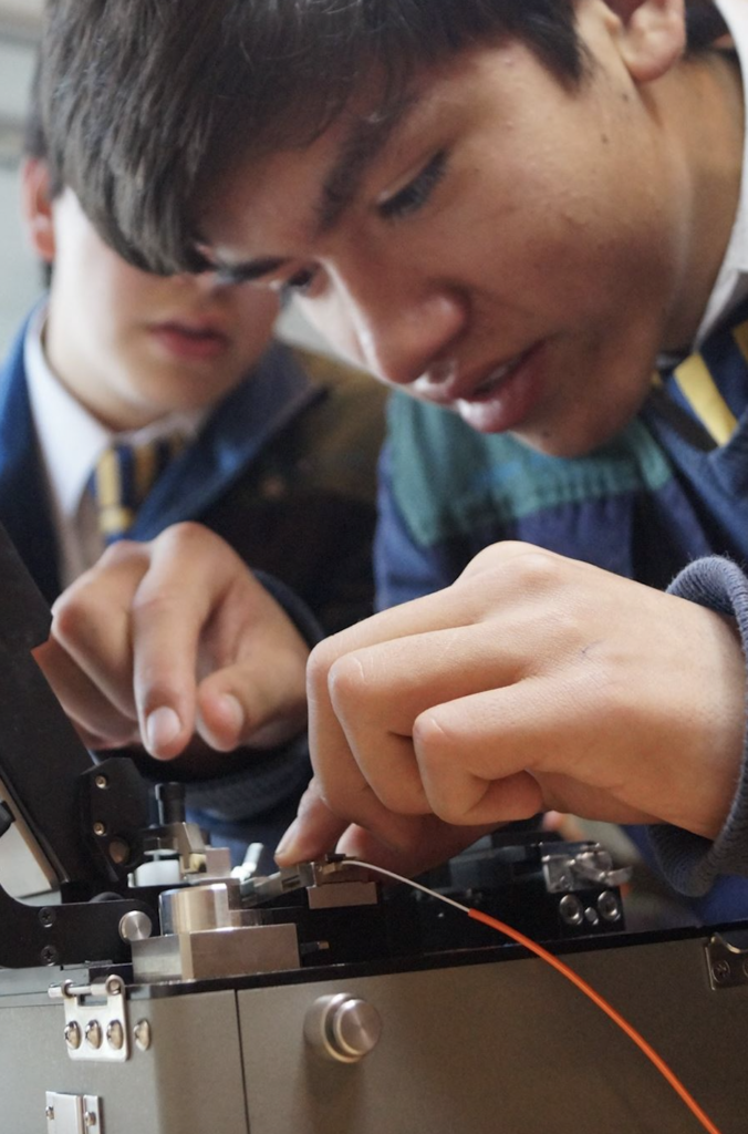 Alumno realizando enlace de fibra óptica